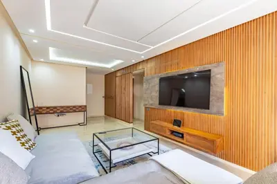 a living room with a couch and a tv on a wall at New! Appt Spacieux et Lumineux à Menara Garden in Marrakech
