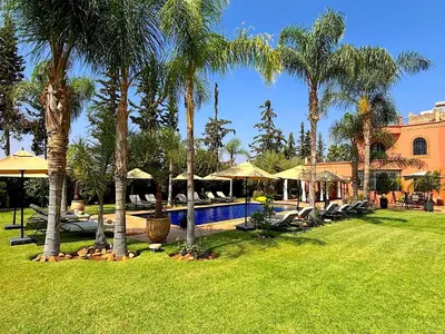 a resort with a swimming pool and palm trees at Palais Ona in Marrakech