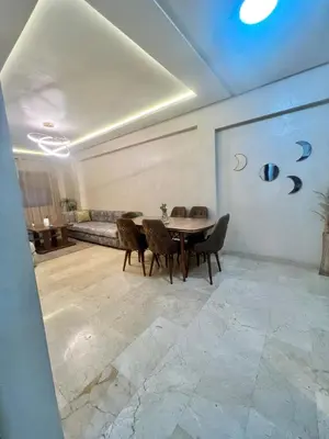 a dining room with a table and chairs and a couch at Bel Appartement nour 5 in Marrakech