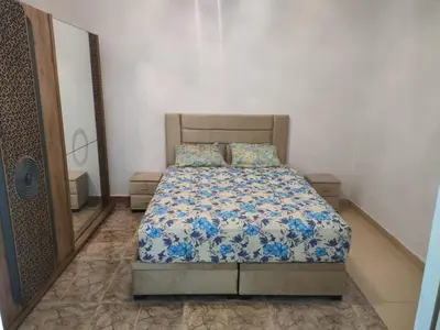 a bedroom with a bed with blue and white sheets at Appartement de luxe in Marrakech
