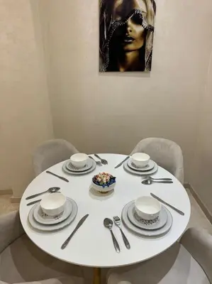 a white table with plates and silverware on it at Appartement à Gueliz près de toute commodité in Marrakech