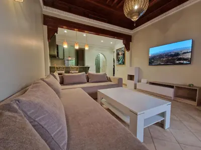 a living room with a couch and a table at les jardins de la palmeraie 2 appart in Marrakech