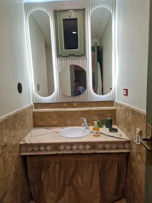 a bathroom with a sink and two mirrors at les jardins de la palmeraie 2 appart in Marrakech