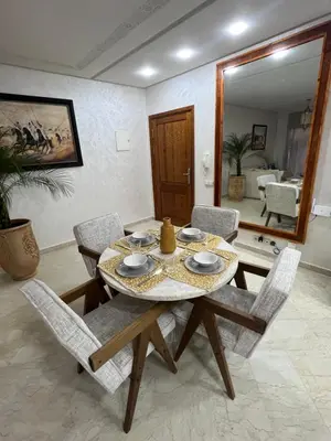 a dining room with a table and chairs and a mirror at Appartement Marrakech - quartier Gueliz in Marrakech