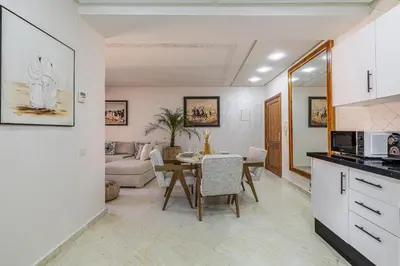a kitchen and living room with a table and a couch at Appartement Marrakech - quartier Gueliz in Marrakech