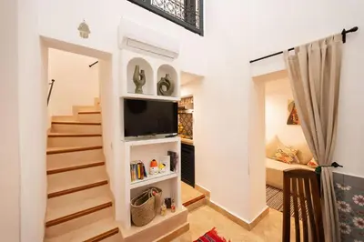 a living room with stairs and a tv at Dar Coco 180 in Marrakech