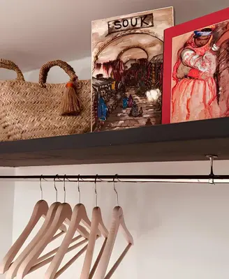 a shelf with several pictures and a basket and hangers at Dar Coco 180 in Marrakech
