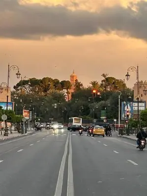 a city street with cars and motorcycles on the road at appartement au coeur de marrakech proche de tout in Marrakech