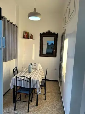 a dining room with a table with chairs and a mirror at appartement au coeur de marrakech proche de tout in Marrakech