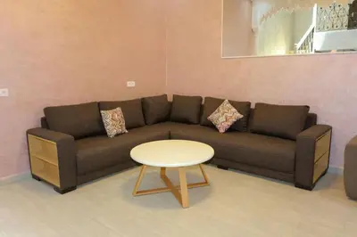 a living room with a couch and a table at Riad Norakech nah zu allen Touristen-Attraktionenr in Marrakech