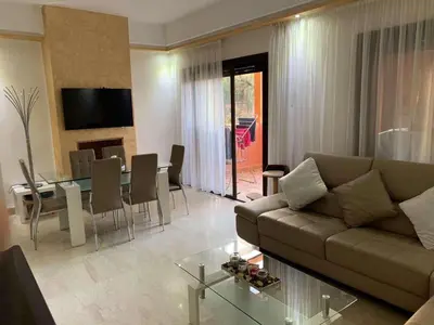 a living room with a couch and a table at Beautiful cozy apartment with pool in Marrakech