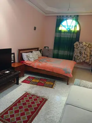 a bedroom with a bed and a couch and a window at Villa Lmima Malika in Marrakech