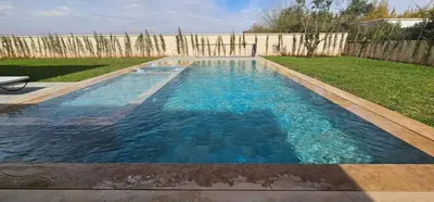 a swimming pool with blue water in a backyard at Villa privée sans vis-vis in Marrakech