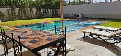 a pool with a table and chairs and a table at Villa privée sans vis-vis in Marrakech