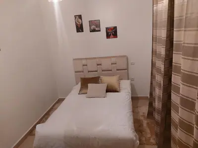 a small bedroom with a bed with white sheets at Marrakech in Marrakech