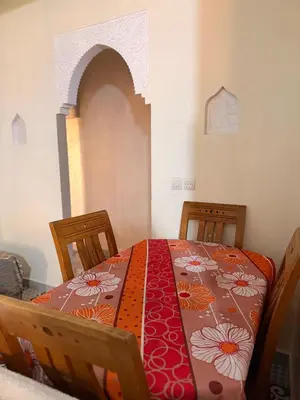 a bedroom with a table with a red and orange table cloth at Julie Airport Marrakech Apartments in Marrakech