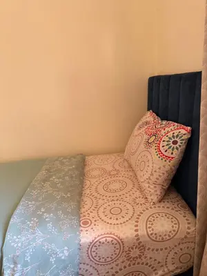 a bed with two pillows on top of it at Julie Airport Marrakech Apartments in Marrakech