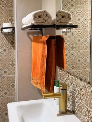a bathroom with a sink and towels on a mirror at Julie Airport Marrakech Apartments in Marrakech