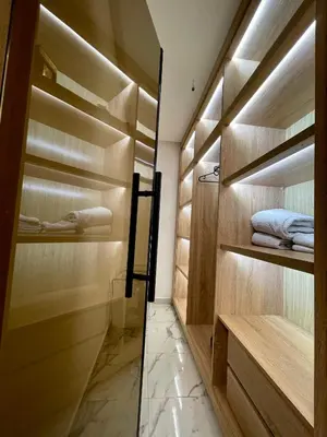 a walk in closet with wooden cabinets and a glass door at Victorious Suites in Marrakech