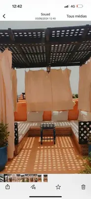 a patio with a bench under a pergola at Très joli appartement à Atlas Golf Resort in Marrakech