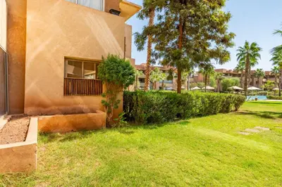 a building with a window and a green yard at Elegant Apartment in Prestigia Golf Marrakech in Marrakech