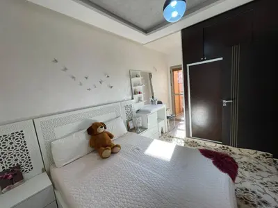 a teddy bear sitting on a bed in a bedroom at Plaza sejour in Marrakech