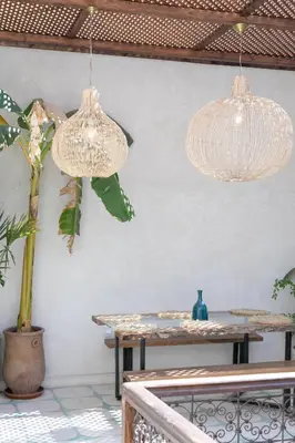two hanging lights in a room with a table at Riad Lamalika in Marrakech