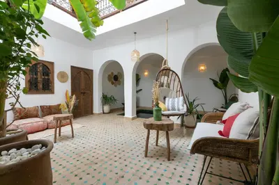 a living room filled with furniture and plants at Riad Lamalika in Marrakech