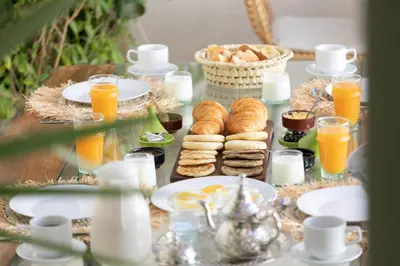 a table topped with plates of food and orange juice at Riad Lamalika in Marrakech