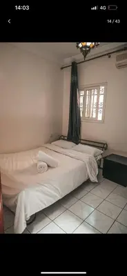 a bedroom with two beds with white sheets and a window at 4 bedrooms house & swimming pool in Marrakech