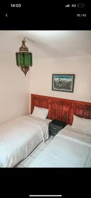 two beds sitting next to each other in a bedroom at 4 bedrooms house & swimming pool in Marrakech