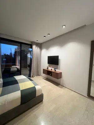 a bedroom with a bed and a flat screen tv at Villa familiale avec piscine chauffée La Dolce Vita in Marrakech