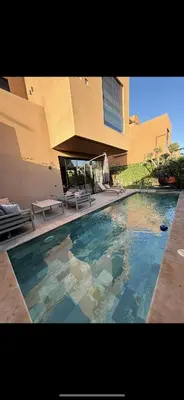 a swimming pool in front of a building at Villa familiale avec piscine chauffée La Dolce Vita in Marrakech