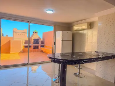 a kitchen with a black counter top and a refrigerator at Rare ! duplex avec vue sur les toits de Marrakech in Marrakech