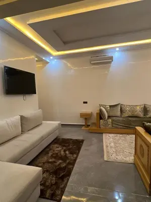 a living room with a couch and a flat screen tv at Appartement racha in Marrakech