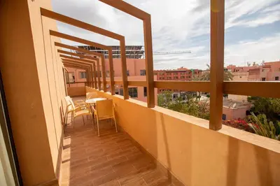 a balcony with a table and chairs and a view at Élégance et Prestige à Gueliz Appartement 3 chambres in Marrakech