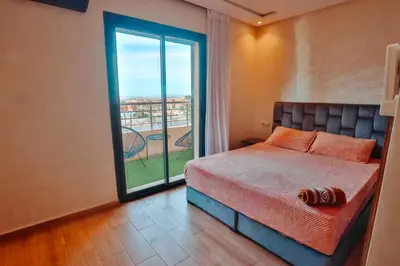 a bedroom with a bed and a large window at Best Apartment Marrakech G35 in Marrakech
