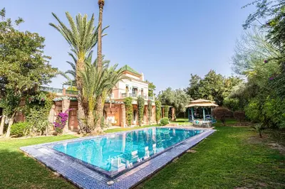 a swimming pool in the yard of a house at Villa palmeraie marrakech in Marrakech