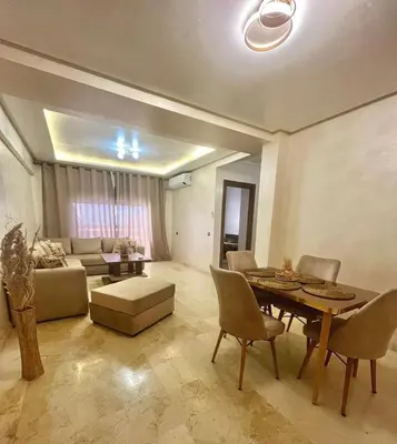 a living room with a table and a couch at Appartement de luxe à Marrakech in Marrakech