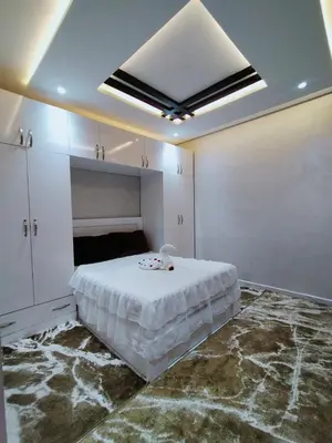 a white bedroom with a bed and a ceiling at Villa fahloui in Marrakech