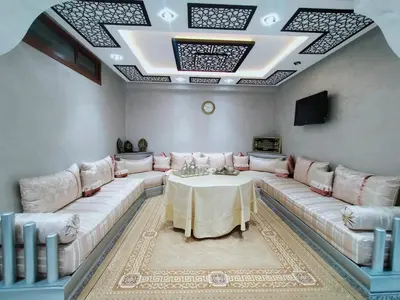 a living room with a large couch and a table at Villa fahloui in Marrakech