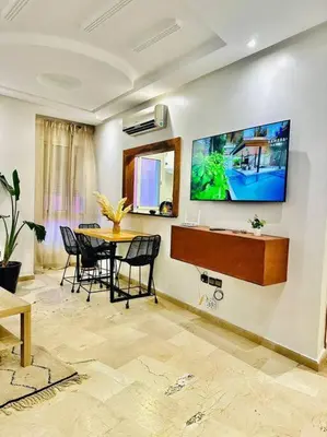 a dining room with a table and a tv on a wall at Cosy House Marrakech Semlalia - Gueliz Center in Marrakech