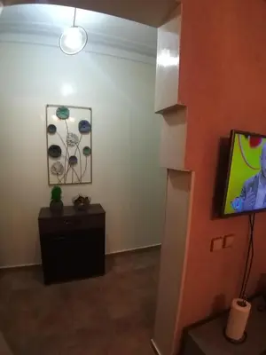 a living room with a tv and a table at Sweet home in Marrakech