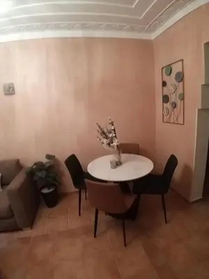 a living room with a table and chairs and a couch at Sweet home in Marrakech