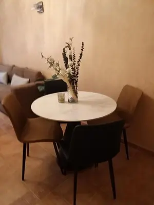 a table with chairs and a vase of flowers on it at Sweet home in Marrakech