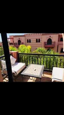 a balcony with a table and chairs and a building at مراكش in Marrakech