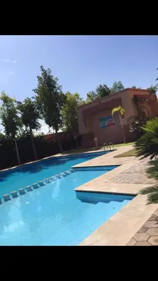 a swimming pool with blue water in front of a building at مراكش in Marrakech