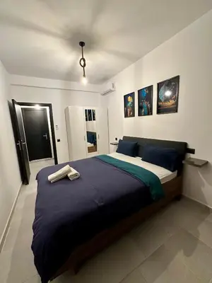 a bedroom with a large bed with blue sheets at Luxury Appartement Marjane in Marrakech