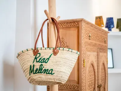 a rattan bag hanging next to a wooden cabinet at Riad Melina Au Coeur de la Medina Petit Dejeuner in Marrakech