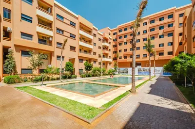 an apartment with a swimming pool in a building at Confortable & Très Bien Noté - Vue Piscine, Proche M Avenue, Piscine, Fibre Optique, Parking in Marrakech
